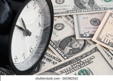 Time is money. Alarm clock and dollar banknotes.