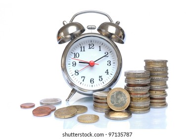 Time is money - Alarm clock and piles of Euro coins on white background