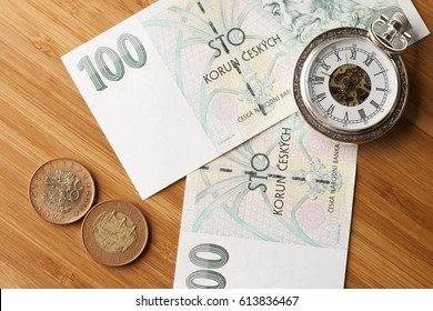 Time is money concept .Czech crowns on wooden background.