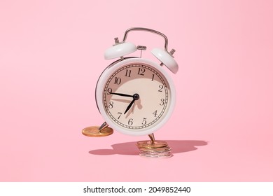 Time Is Money Concept On Pink Background. Alarm Clock With Money Still Life