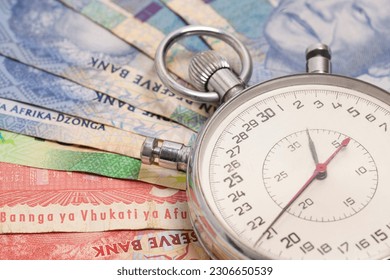 Time is money concept, stopwatch on South African money rand banknote.