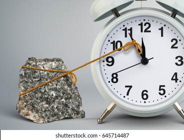 Time on clock stop by stone, delay concept