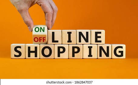 Time to online shopping. Male hand turns the cube and changes the expression 'offline shopping' to 'online shopping'. Beautiful orange background. Business and online shopping concept. Copy space.