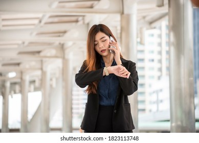 Time out concept. Business woman looking at wrist watch and using mobile phone before meeting, Urgent work. Smart woman check the schedule before going to the office. Time out for appointment meeting