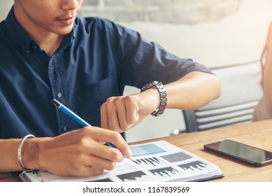 Time out concept.Business man seeing wrist watch to check time at office - Powered by Shutterstock