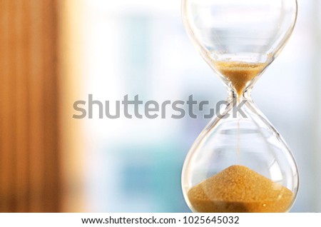 Time passing concept,urgency and running out of time. Sand fall in hourglass