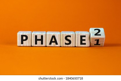 Time for Phase 2. Turntd a cube and changed the word 'Phase 1' to 'Phase 2'. Beautiful orange background. Business concept. Copy space.