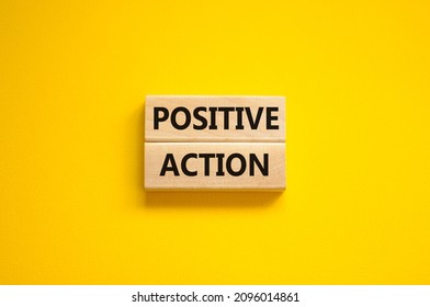 Time to positive action symbol. Wooden blocks with concept words 'Positive action'. Beautiful yellow background. Business and positive action concept. Copy space.