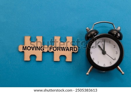 Time to progress! Two puzzle pieces with "Moving Forward" and an alarm clock hint at taking action and achieving goals.