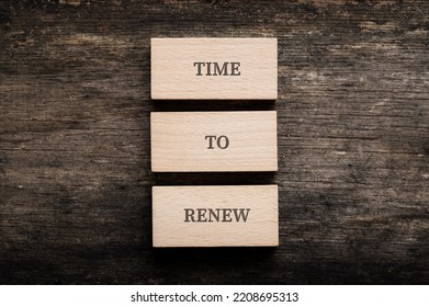 Time To Renew Sign Spelled On Three Stacked Wooden Blocks Placed Over Rustic Wooden Background.