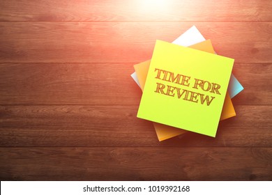 Time For Review, the phrase is written on multi-colored stickers, on a brown wooden background. Business concept, strategy, plan, planning.
