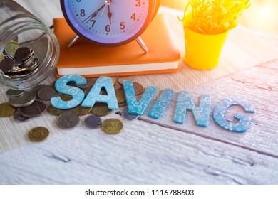 Time to SAVING concept with stack of coin and vintage alarm clock on wooden table in daylight background, business and financial concept idea. Selective focus