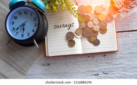 Time to SAVING concept with stack of coin and vintage alarm clock on wooden table in daylight background, business and financial concept idea. Selective focus