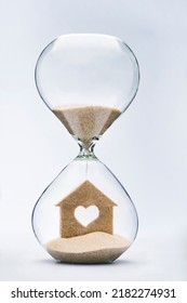 Time is a shelter. Building a home with love concept with falling sand taking the shape of a heart house inside a hourglass. - Shutterstock ID 2182274931