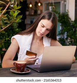 Time For Some Retail Therapy. Shot Of A Young Woman Using Her Debit Card To Shop On Her Laptop.