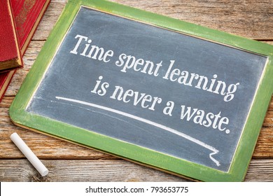 Time spent learning in never a waste - inspiraitonal quote on a slate blackboard with a white chalk and a stack of books against rustic wooden table - Powered by Shutterstock