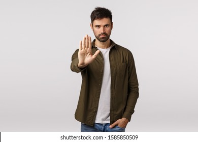Time to stop. Concerned friend asking quit, warn someone, prevent making same mistake. Serious-looking assertive and confident young man pulling stop gesture, extend arm in forbid sign