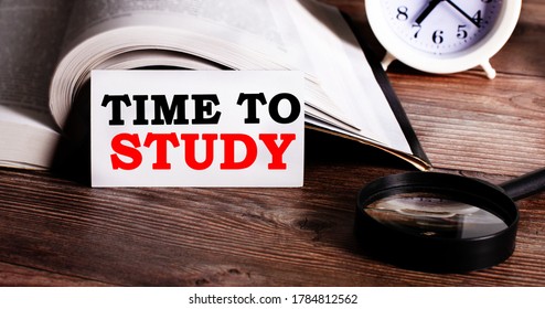 TIME TO STUDY is written on a white card next to an open book and a white alarm clock. Educational concept