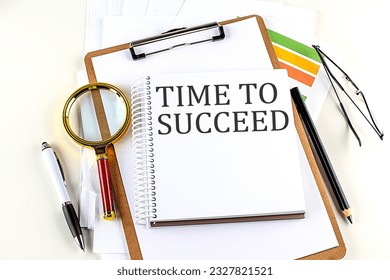 TIME TO SUCCEED text on a notebook with clipboard on white background