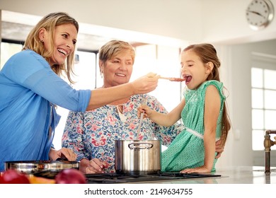 Time For A Taste Test. Shot Of A Multi Generational Family Cooking Together At Home.