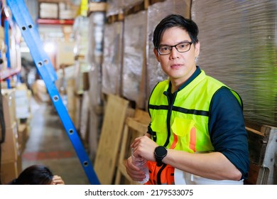 Time For A Tea Break Concept. Asian Male Warehouse Industrial, Factory And Energy Engineer Specialist Drinking Water Sitting On Stair At Warehouse Office Factory Workplace.