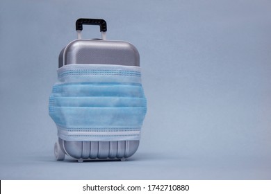 Time To Travel. The Concept Of Safe Rest During A Pandemic Covid-19 Coronavirus. Suitcase For Travel With A Medical Mask