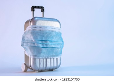 Time To Travel. The Concept Of Safe Rest During A Pandemic Covid-19 Coronavirus. Suitcase For Travel With A Medical Mask