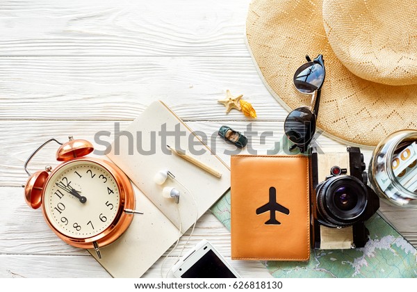 time\
to travel concept, space for text. map camera passport money phone\
with empty screen sunglasses and clock hat shells car toy on white\
wooden background. hello holiday, planning\
vacation