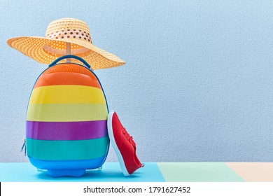 Time to travel. Summer vacation. Travelling abroad. Colourful suitcase, shoes and female straw hat, place for text