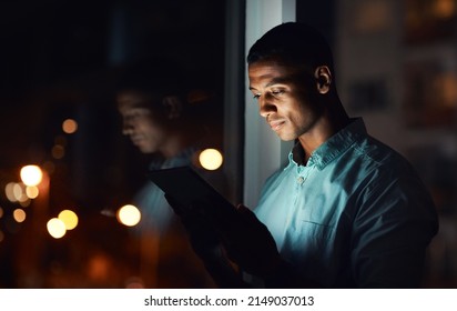 Its Time You Also Get Connected. Shot Of A Handsome Young Businessman Using A Digital Tablet While Working Late In His Office.