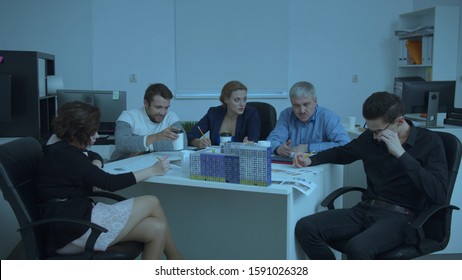 Timelaps, people sit at a table and work with schemes