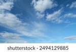 Timelapse. Floating fluffy clouds. Beautiful sunny blue sky with wispy smoky white cumulus and cirrus on different layers.