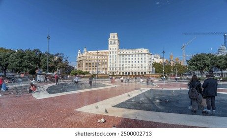 Timelapse Hyperlapse of Activity at Placa de Catalunya, Barcelona's Central Square. A Dynamic Scene with People, a Central Fountain, and a Flowerbed Serving as the Lively Backdrop to City Life
