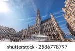 Timelapse hyperlapse of Town Hall (Hotel de Ville) on the Grand Place in Brussels, Belgium. Looking up at the Gothic tower and facade. A UNESCO World Heritage Site and major tourist destination