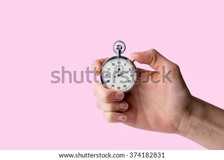 timer held in hand, pink background