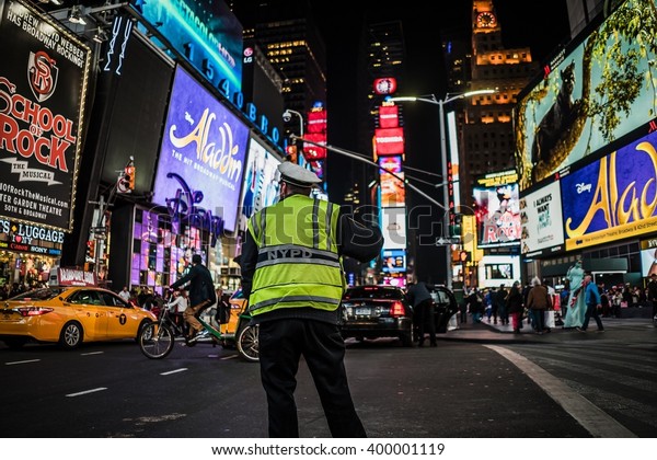 Times Square, New York City, United States of\
America - Circa March 2016 - A selective focus shot of a NYPD\
police officer on times\
square