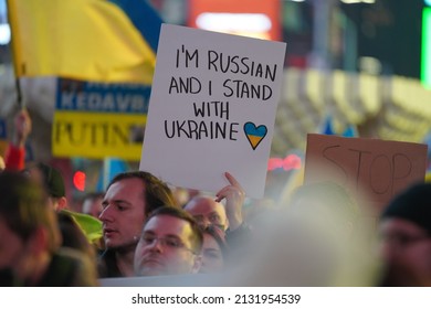 TIMES SQUARE, NEW YORK, NY - MARCH 2, 2022: Crowd of people, New Yorkers gather “Stand with Ukraine” rally holding posters and flags. Protest against Russian invasion war attack