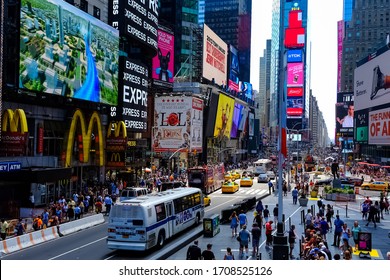 Times Square With Yellow New York City Taxi Cabs And Tour Buses Driving Through Colorful Billboards. Manhattan, New York. USA - August 25, 2015.