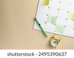 Timetable. Calendar page with sticky notes, pen and alarm clock on beige background, top view. Space for text