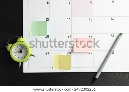 Timetable. Planner with sticky notes, pen and alarm clock on black wooden table, top view