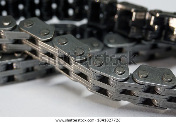 Timing chain of an engine of a modern car. Macro\
photography. Individual links of the chain are in focus, the\
background is blurred.