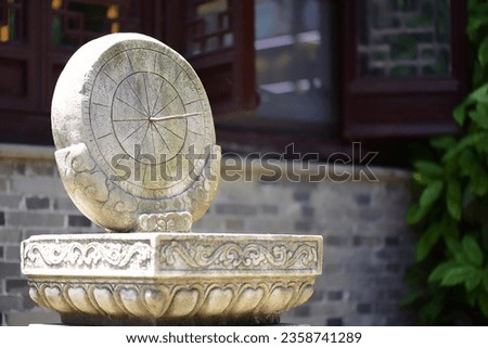 The timing instrument in front of the windows of ancient buildings under the summer sun is a sundial and a sundial. The Chinese characters in the picture mean: Twelve double hours.
