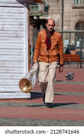 Timisoara, Romania - March 15, 2018: Man Walking On The Street, Carrying A Musical Instrument. Real People.