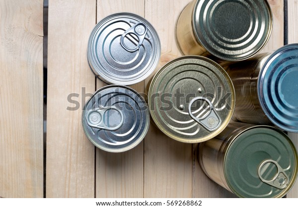 Tin cans for food on\
wooden background