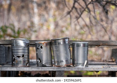 tin cans for target practice sitting on weathered board