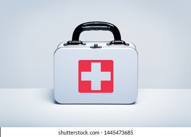 Tin first aid kit with cross emblem on grey background