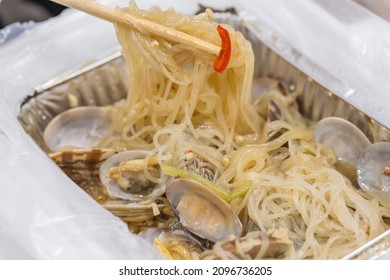 A Tin Foil Box Of Cooked Clams And Rice Noodles