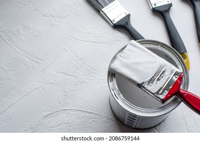  tin paint can and new paintbrush on white background