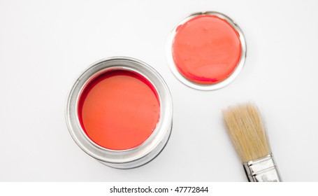 A Tin Of Red Paint With A Brush And A Lid