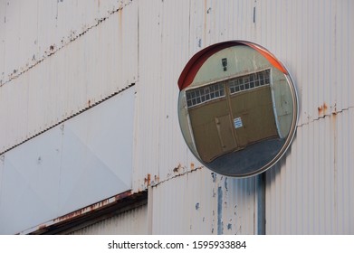 Tin Shed With Convex Mirror Showing View Round Corner With Warehouse Doors